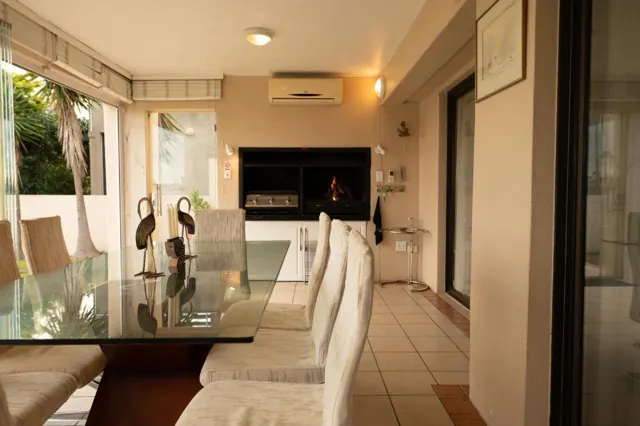 Braai room with built-in fireplace and glass dining table
