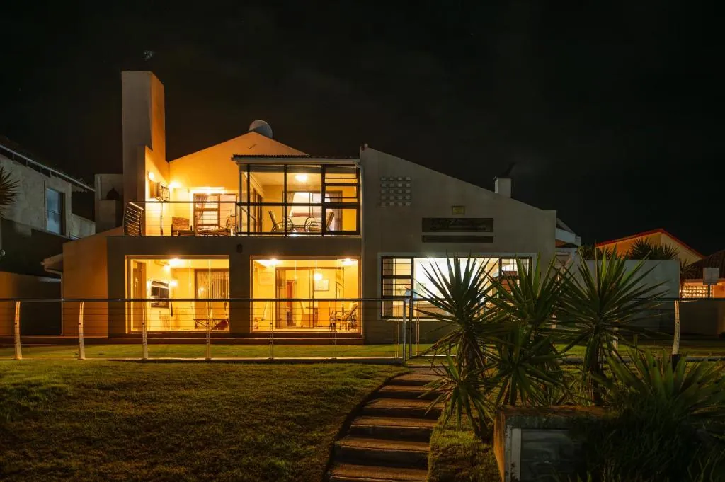 The guest house lit up at night, seen from the marina lawn