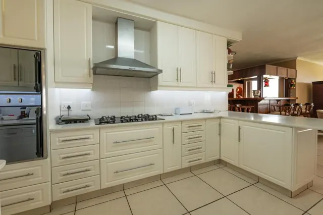 White kitchen with gas hob, double oven and extractor