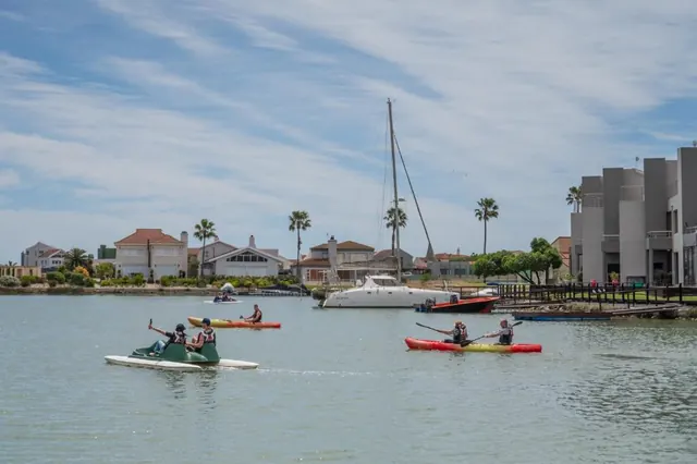Kayaks and a pedal boat out on the marina in front of the waterfront homes